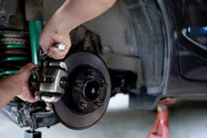 Technician is using a wrench to remove the locking nut of Brake caliper in service shop maintenance concept brake system